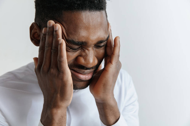Estressado jovem afro-americano homem com terrível forte dor de cabeça
. - Foto, Imagem
