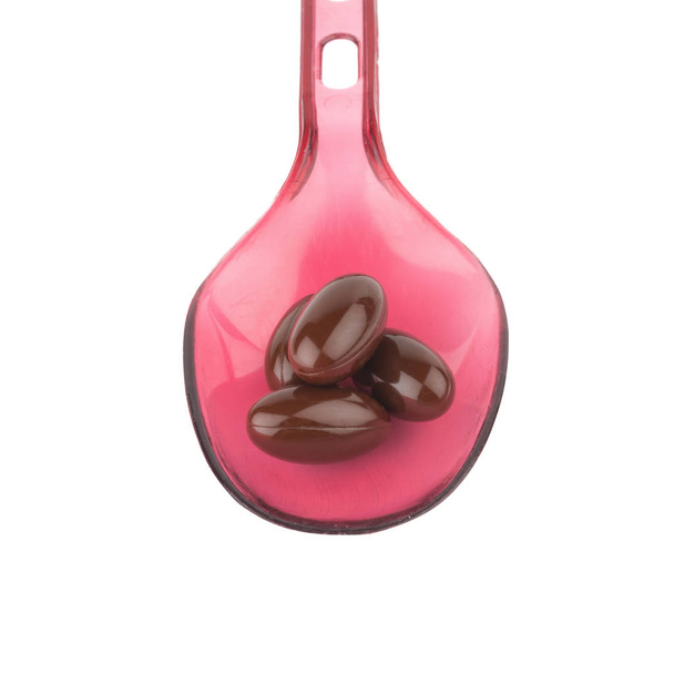 vitamine E. nourriture supplémentaire. couleur brun capsule. cuillère rouge est
 - Photo, image