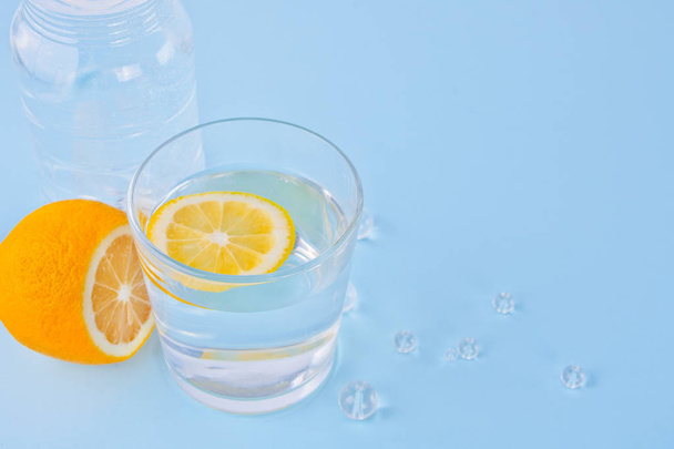 water with lemon on the blue background. Copy space. - Photo, Image