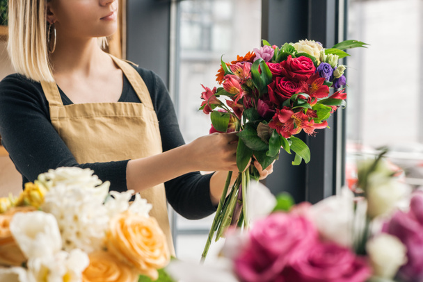 Partial view of florist making bouquet in flower shop - Foto, imagen