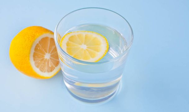 water with lemon on the blue background. - Foto, Bild