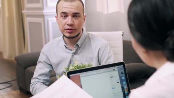Young man is interviewing for job at female manager in office - Záběry, video