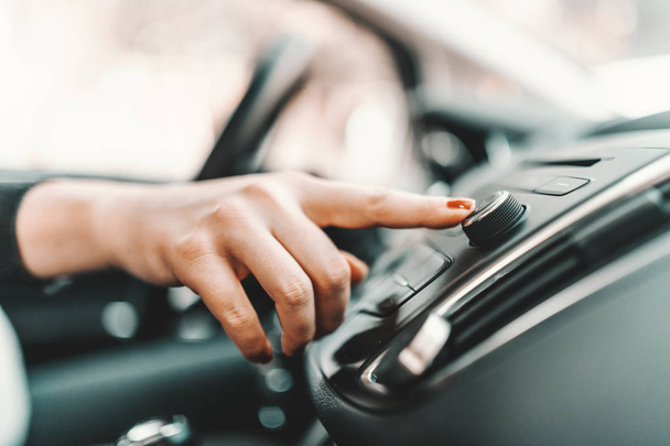 Close up de jovem mulher branca grávida dirigindo carro e mudando estação de rádio
. - Foto, Imagem