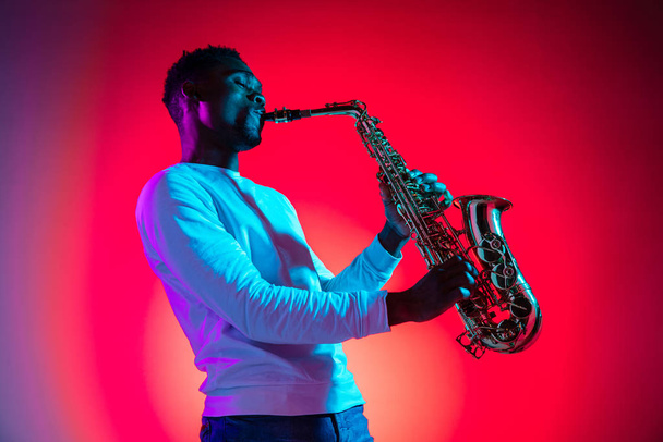 African American jazz musician playing the saxophone. - 写真・画像