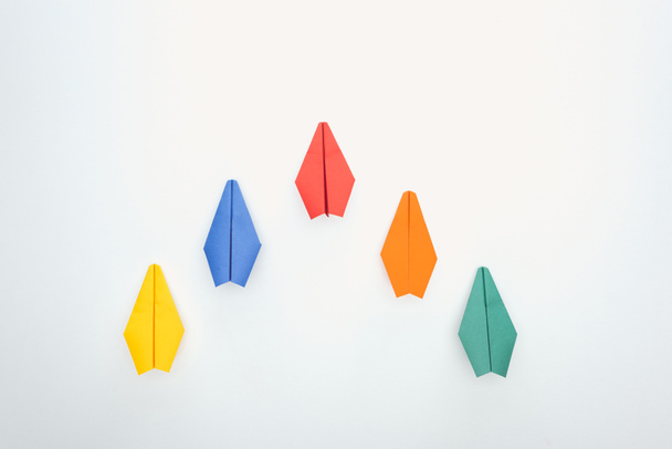 Flat lay with colorful paper planes on white surface - Foto, Bild