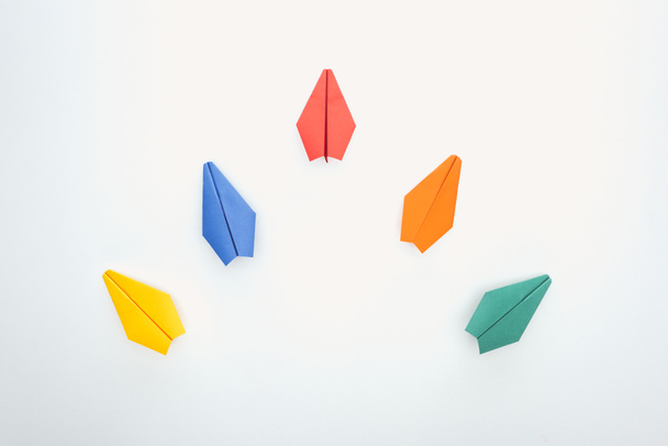 Flat lay with colorful paper planes on white surface - Foto, Bild