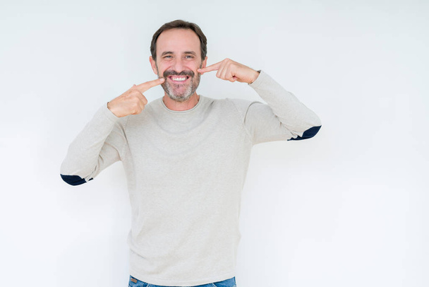 Homem sênior elegante sobre fundo isolado sorrindo confiante mostrando e apontando com os dedos dentes e boca. Conceito de saúde
. - Foto, Imagem