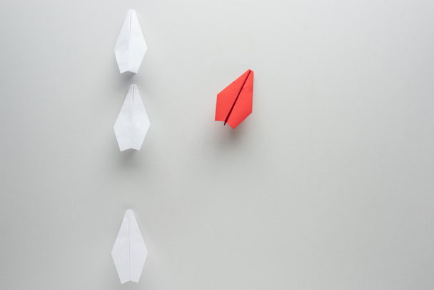 Flat lay with white and red paper planes on grey surface - Photo, Image