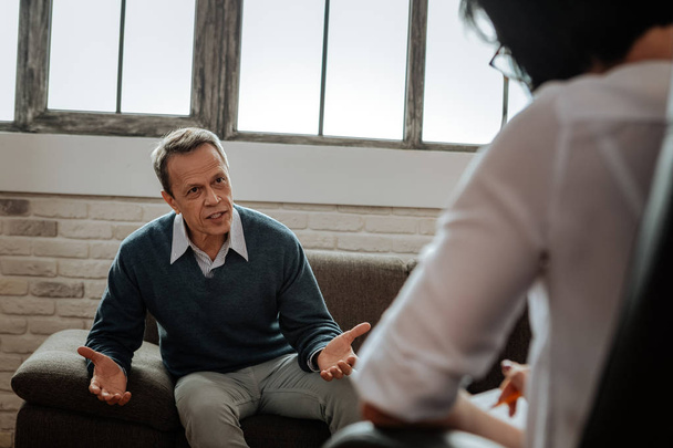 Expressive short-haired adult man talking with his psychotherapist - Photo, Image