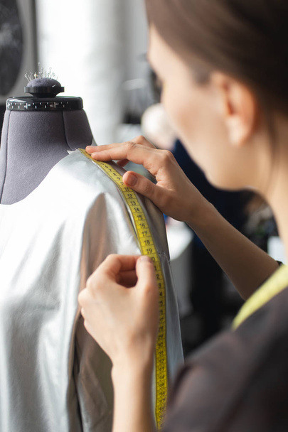Tailor taking measurements for sewing suit at tailors shop. Custom Made Cloth Concept. - Fotó, kép
