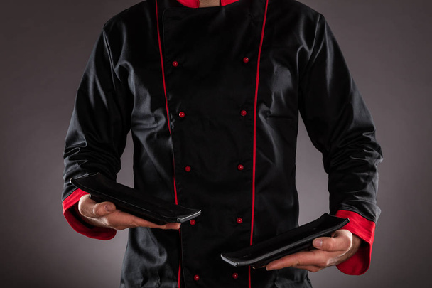 Closeup of chef holding empty plates. - Foto, afbeelding