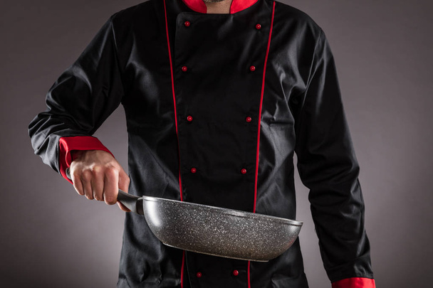 Closeup of chef holding empty frying pan - Zdjęcie, obraz