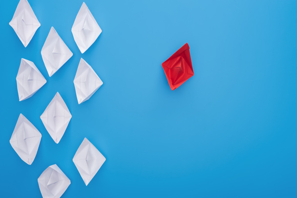 Flat lay com barcos de papel branco e vermelho na superfície azul
 - Foto, Imagem