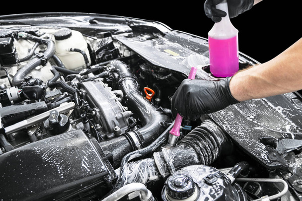 A man cleaning car engine with shampoo and brush. Car detailing or valeting concept. Selective focus. Car detailing. Cleaning with sponge. Worker cleaning. Car wash concept solution to clean - Foto, Bild