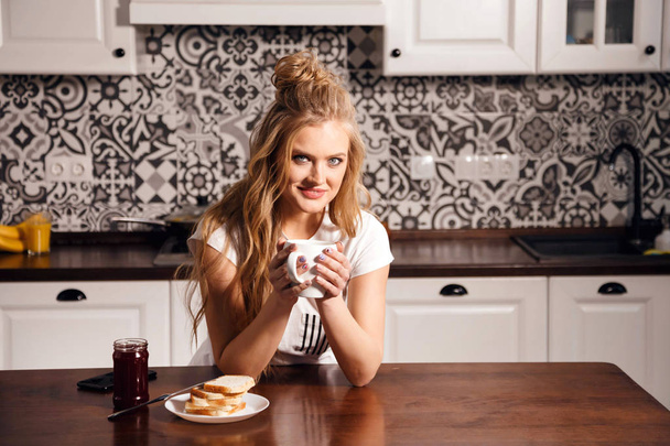 Woman with Cup in the Kitchen - Photo, Image