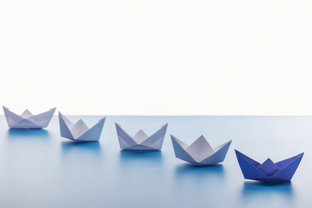 Paper boats on light blue surface on white background - Zdjęcie, obraz