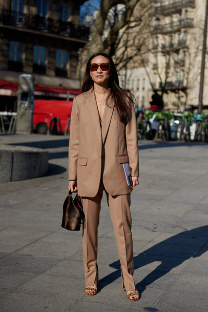 A trendy woman in fashionable outfit is pictured on the street during the Paris Fashion Week Fall/Winter 2019/2020 in Paris, France. - Zdjęcie, obraz