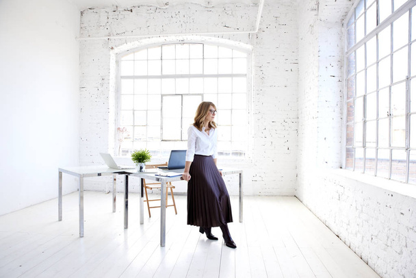 Full length shot of elegant middle aged businesswoman standing at office desk and looking out the window while deep in thought.  - Fotoğraf, Görsel