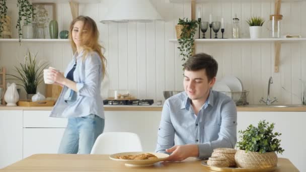 girl serves breakfast putting dumplings on plate kisses guy - Footage, Video