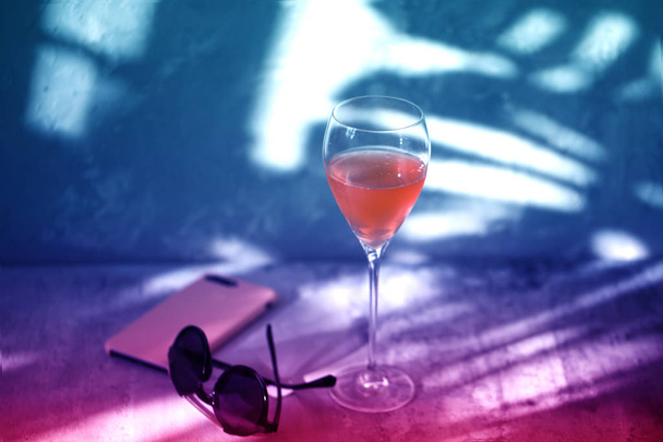 Стакан вина на фиолетовом фоне. неоновое вино
. - Фото, изображение