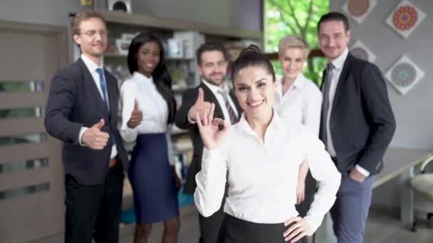 Mujer de negocios confiada de pie frente a su exitoso equipo
 - Imágenes, Vídeo