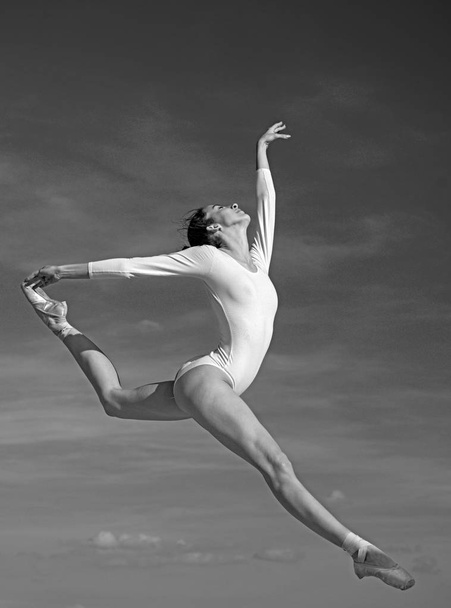 Graceful beauty. Concert performance dance. Young ballerina jumping on blue sky. Classic dance style. Cute ballet dancer. Pretty woman in dance wear. Practicing art of classical ballet. Ballet class - Photo, Image