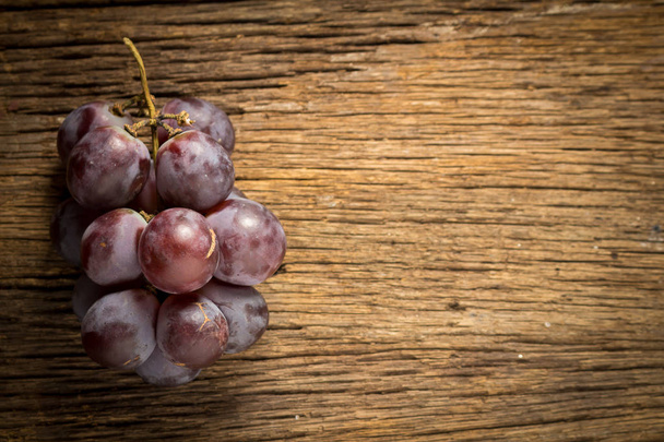Uvas rojas sobre mesa de madera
  - Foto, imagen