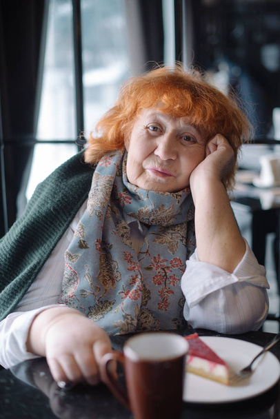Mujer anciana en la cafetería y bebe café con pastel
 - Foto, Imagen