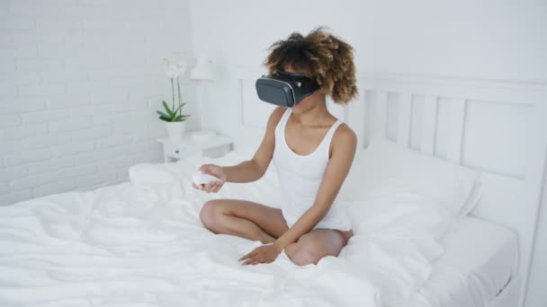 Content woman in VR glasses on bed - Metraje, vídeo