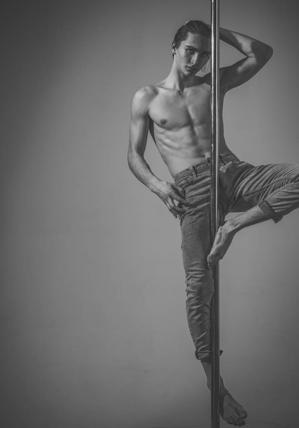 Sport and art concept. Athlete, sportsman performing pole dancing moves, - Zdjęcie, obraz