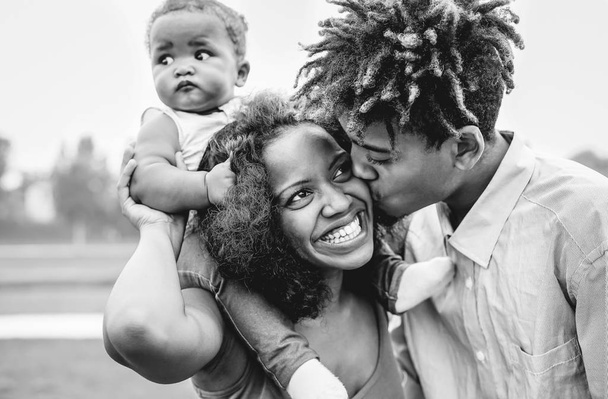 Happy African family having fun in a park outdoor - Mother and father with their daughter enjoying time together in a weekend day - Love and happiness concept - Black and white edit - Photo, Image