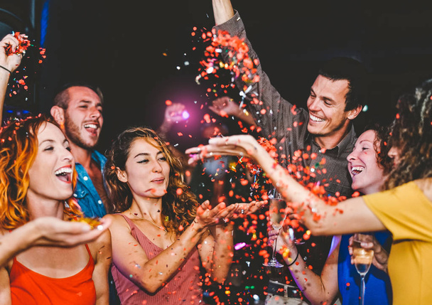 Des amis heureux font la fête en lançant des confettis dans le club - Jeunes du millénaire s'amuser à célébrer dans la boîte de nuit - Vie nocturne, divertissement et vacances festives pour les jeunes concept
 - Photo, image