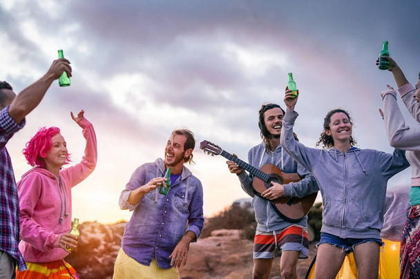 Happy přátelé což stranu při západu slunce při kempování další pláž - mladí lidé baví tanec a pití piva venkovní - Tisíciletá, léto, dovolená a mládež svátků životní styl koncept - Fotografie, Obrázek