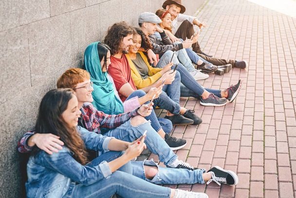 Grupo de amigos que utilizan sus teléfonos móviles inteligentes al aire libre - Millennial jóvenes adictos a las nuevas tendencias de tecnología aplicación - Concepto de personas, tecnología, redes sociales, generación z y estilo de vida juvenil
 - Foto, Imagen