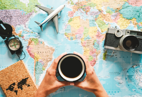 Widok z góry młodej kobiety planowania jej urlop za pomocą mapy świata podczas picia kawy - turystyczny, wskazując następnego podróż przeznaczenia - koncepcja przygoda, turystyka i podróże życia ludzi - Zdjęcie, obraz