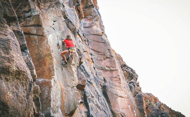 Lekkoatletycznego mężczyzna wspinaczki skalnej ściany - pnącze szkolenia i wykonywania na góra kanion - pojęcie sport ekstremalny, lifestyle zdrowie ludzi i alpinizm - Zdjęcie, obraz