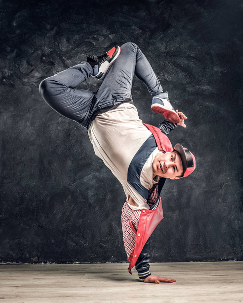 Hip-hop style dancer performs breakdance acrobatic elements. - Photo, Image