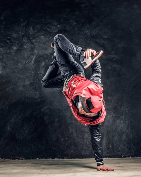 Μοντέρνο τύπος εκτελεί ακροβατικά στοιχεία breakdance. - Φωτογραφία, εικόνα