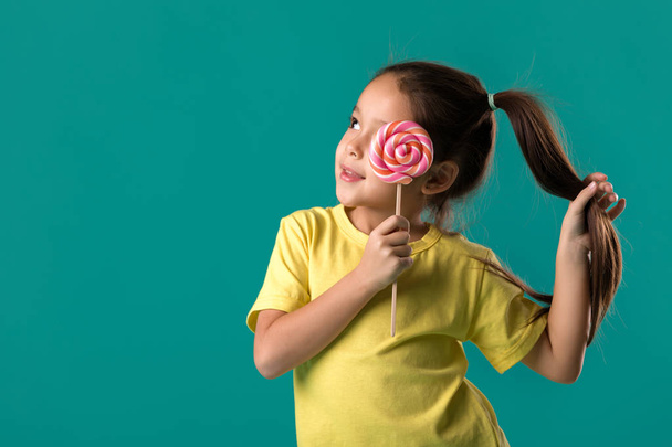 Beautiful cute little girl with a lollipop - Фото, зображення
