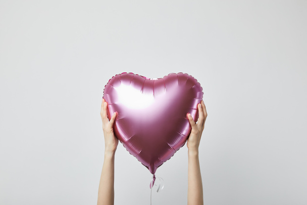 vue recadrée de fille tenant ballon d'air rose en forme de coeur isolé sur blanc
 - Photo, image