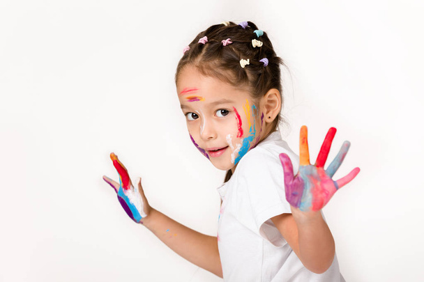 little child girl with hands painted in colorful paint - Фото, изображение