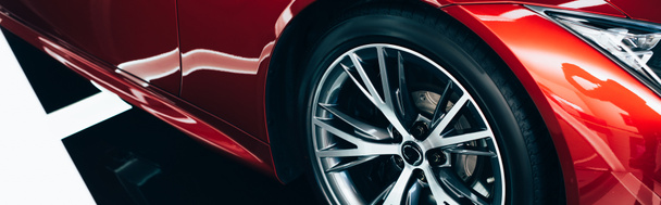 Panoramaaufnahme eines neuen, leuchtend roten Automobils mit metallischem Rad  - Foto, Bild