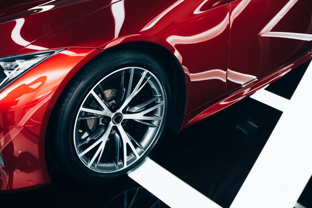 brillant nouvelle automobile rouge avec roue métallique dans la salle d'exposition de la voiture
  - Photo, image