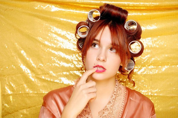 Beautiful girl in hair curlers isolated on gold - Fotoğraf, Görsel