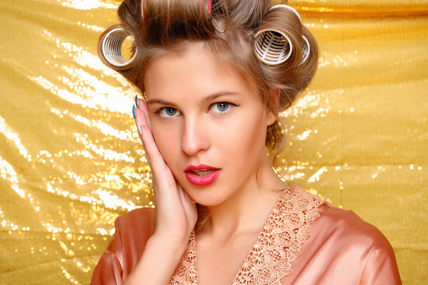 Beautiful girl in hair curlers isolated on gold - Foto, Imagem