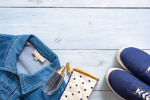Tyylikäs vaatteet näyttävät tasainen lay tyyli sininen pastelli värillinen puinen pöytä. Rento vaatteet kauneus bloggaaja, hipster tyttö, muodikas nuori nainen
. - Valokuva, kuva