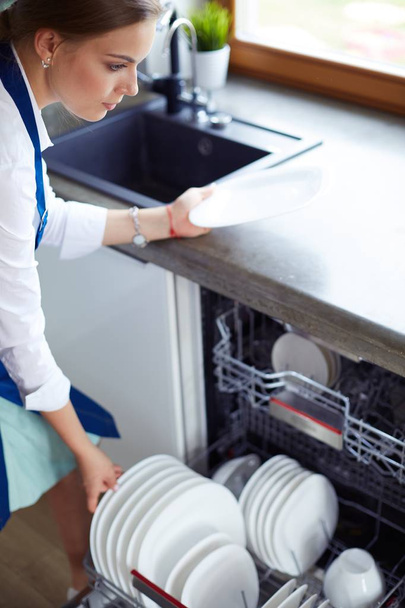 Dishwasher. Young woman in the Kitchen doing Housework. Wash-up - Фото, зображення