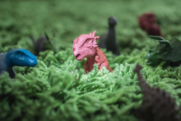 Zabawka dinozaurów w wysokiej trawie miniaturowe dzikiego życia - Zdjęcie, obraz