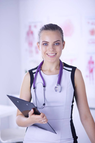 Portrait of friendly female doctor with stethoscope and tablet in hands. - Photo, Image