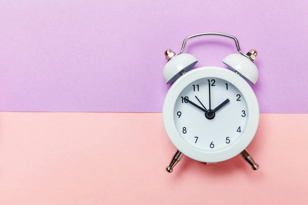 紫ピンクのパステル調の背景にビンテージの目覚まし時計免 - 写真・画像